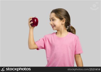 Studio portrait of a beautiful little girl holding a fresh red apple