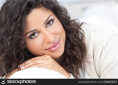 Studio portrait of a beautiful young Latina Hispanic woman smiling resting on her hands