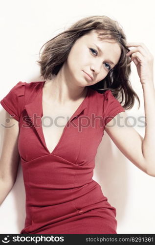 Studio portrait of a beautiful young woman in a red dress on white background