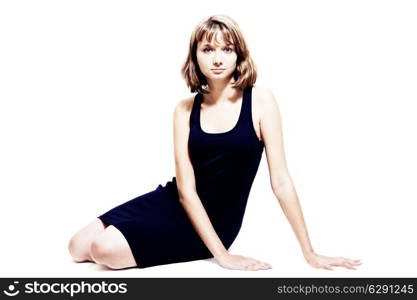 Studio portrait of a beautiful young woman sitting on the floor isolated on white background