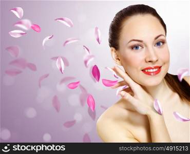 Studio portrait of a beautiful young woman with flowers on background