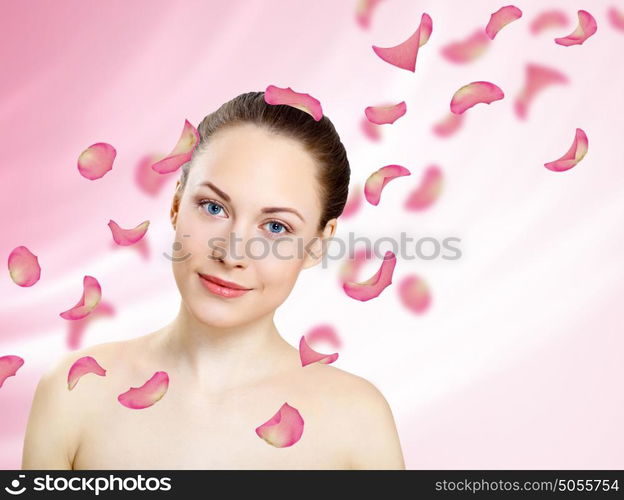 Studio portrait of a beautiful young woman with flowers on background