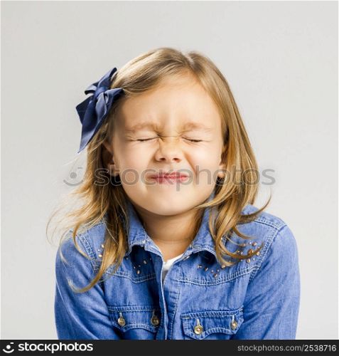 Studio portrait of a cute litle girl closing her eyes