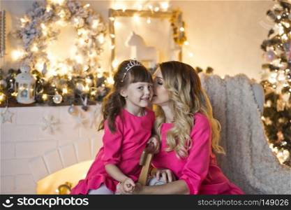 Studio portrait of a family in Christmas decorations.. Mother with her little daughter in Christmas decorations 9902.