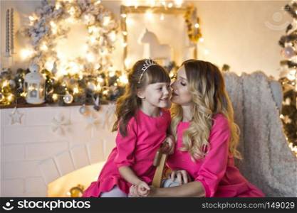 Studio portrait of a family in Christmas decorations.. Mother with her little daughter in Christmas decorations 9903.