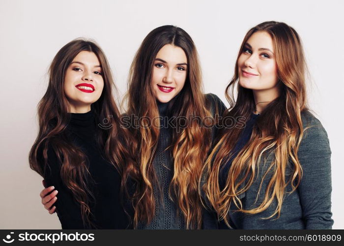 Studio portrait of a group of three young beautiful model smiling and having fun. Consumer concept, winter fashion, attractive young women