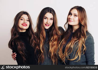 Studio portrait of a group of three young beautiful model smiling and having fun. Consumer concept, winter fashion, attractive young women