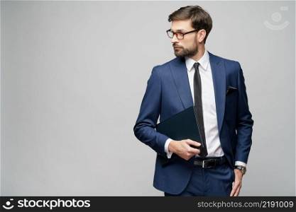 Studio Portrait of a handsome young business man holding document folder. Portrait of a handsome young business man holding document folder