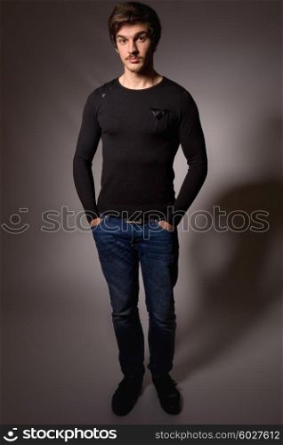 Studio portrait of a handsome young man, full length