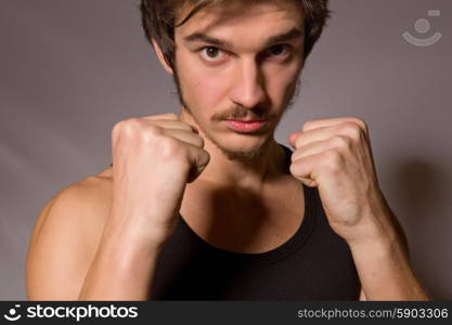 Studio portrait of a handsome young man showing his fists