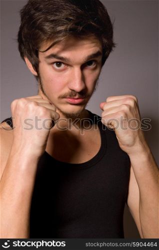 Studio portrait of a handsome young man showing his fists