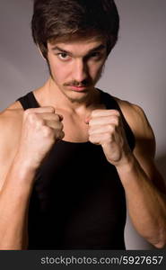 Studio portrait of a handsome young man showing his fists