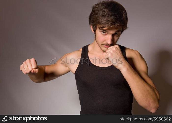 Studio portrait of a handsome young man showing his fists