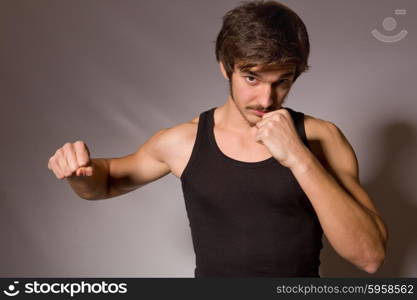 Studio portrait of a handsome young man showing his fists