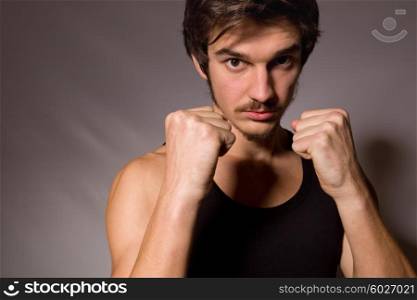 Studio portrait of a handsome young man showing his fists