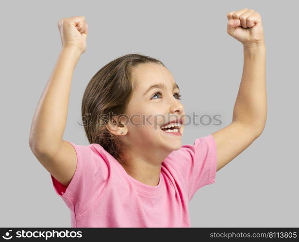 Studio portrait of a happy little girl with arms raised on air