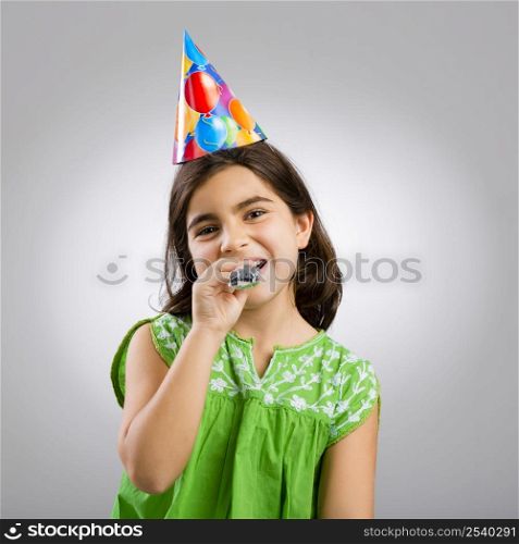 Studio portrait of a little girl wearing a party hat on her birthday