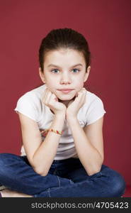 studio portrait of a pretty little girl on a burgundy background