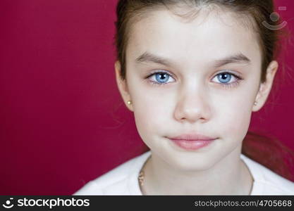 studio portrait of a pretty little girl on a burgundy background