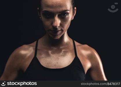 Studio portrait of a sporty young woman posing against a dark background
