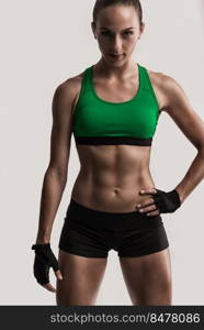 Studio portrait of a sporty young woman posing against a gray background