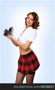 Studio portrait of a woman dressed in retro style with camera