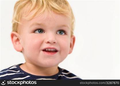 Studio portrait of a young blonde boy with a cute smile