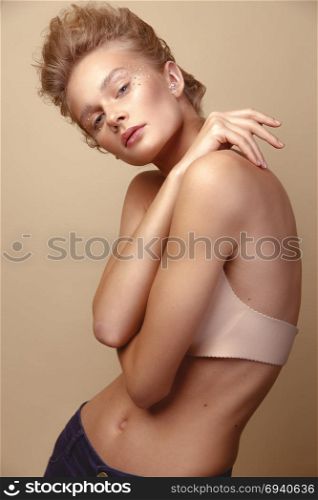 Studio Portrait of a young cute blonde model girl in art makeup with rhinestones. Portrait of cute blonde girl with art makeup