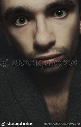Studio portrait of a young handsome man with green eyes