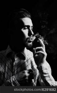 Studio portrait of a young man smoking a cigarette
