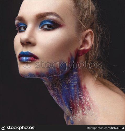 Studio Portrait of a young model girl with stylish makeup in a dark blue tones. Portrait of beautiful girl with blue tones makeup