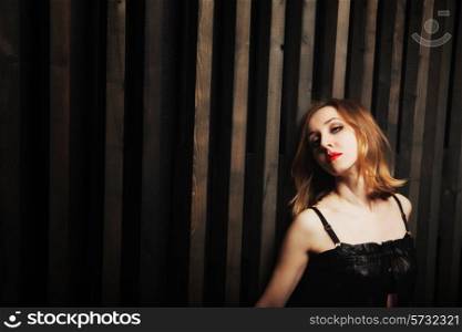Studio portrait of a young passionate woman against a wooden wall