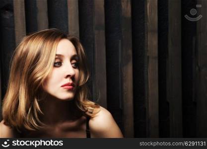 Studio portrait of a young woman against a wooden wall