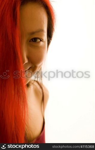 Studio portrait of Asian woman with dyed red hair