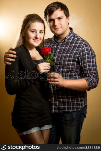 Studio portrait of beautiful couple in love hugging and looking at camera