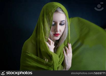 studio portrait of beautiful young woman in green summer shawl