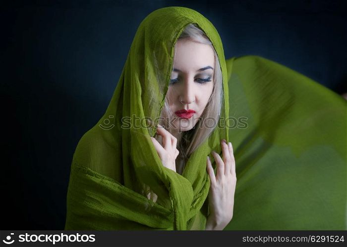 studio portrait of beautiful young woman in green summer shawl