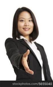 Studio Portrait Of Chinese Businesswoman Reaching Out To Shake Hands