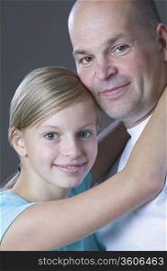 Studio portrait of daughter embracing father