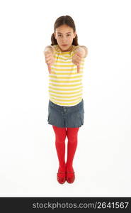 Studio Portrait Of Defiant Young Girl Giving Thumbs Down Gesture