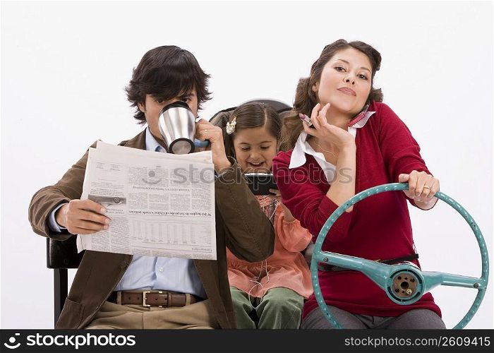 Studio portrait of distracted family in imaginary car