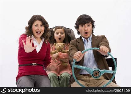 Studio portrait of family in imaginary car about to have an accident