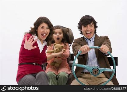 Studio portrait of family in imaginary car about to have an accident