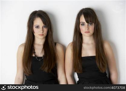 Studio Portrait Of Fashionably Dressed Twin Teenage Girls