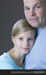 Studio portrait of father and daughter smiling