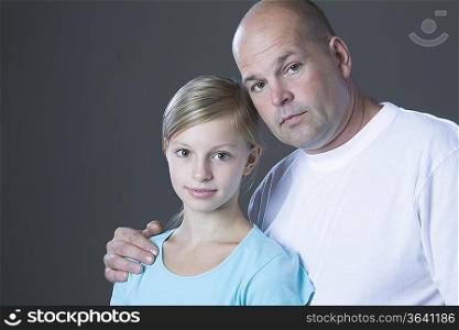Studio portrait of father embracing daughter