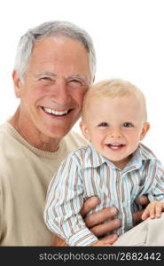 Studio Portrait Of Grandfather Holding Grandson