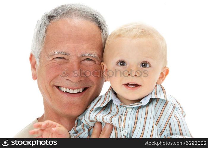 Studio Portrait Of Grandfather Holding Grandson