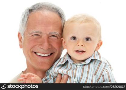 Studio Portrait Of Grandfather Holding Grandson
