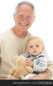 Studio Portrait Of Grandfather Holding Grandson With Teddy Bear